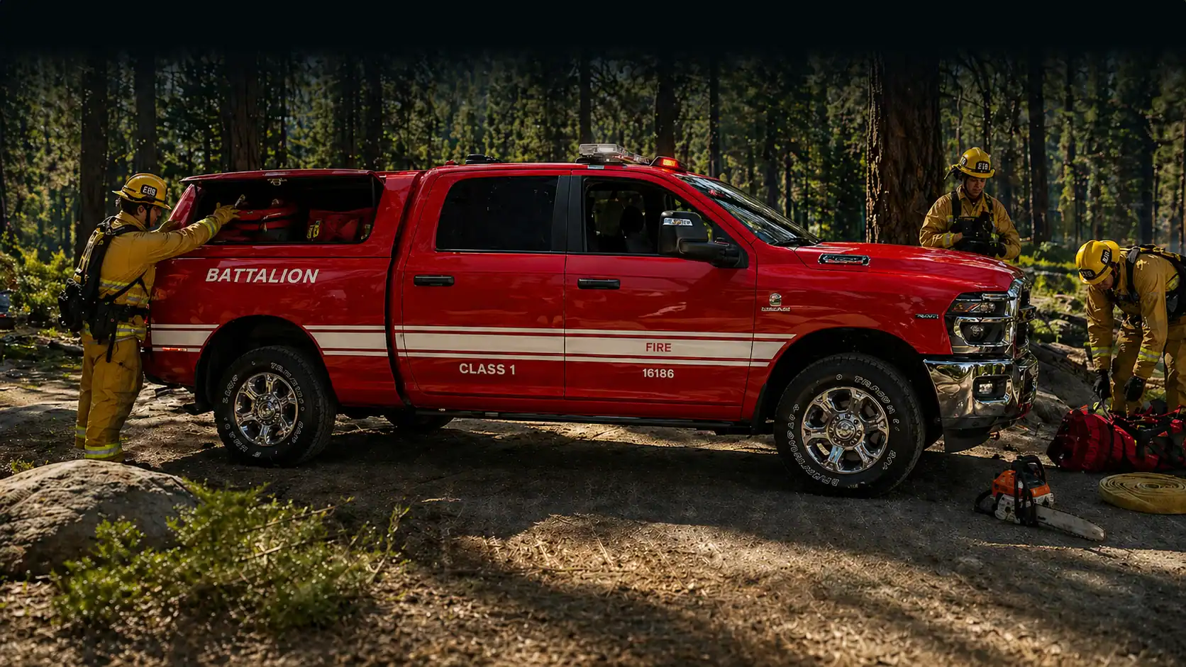 Firefighter rescue team with a red fire truck in a forest setting.